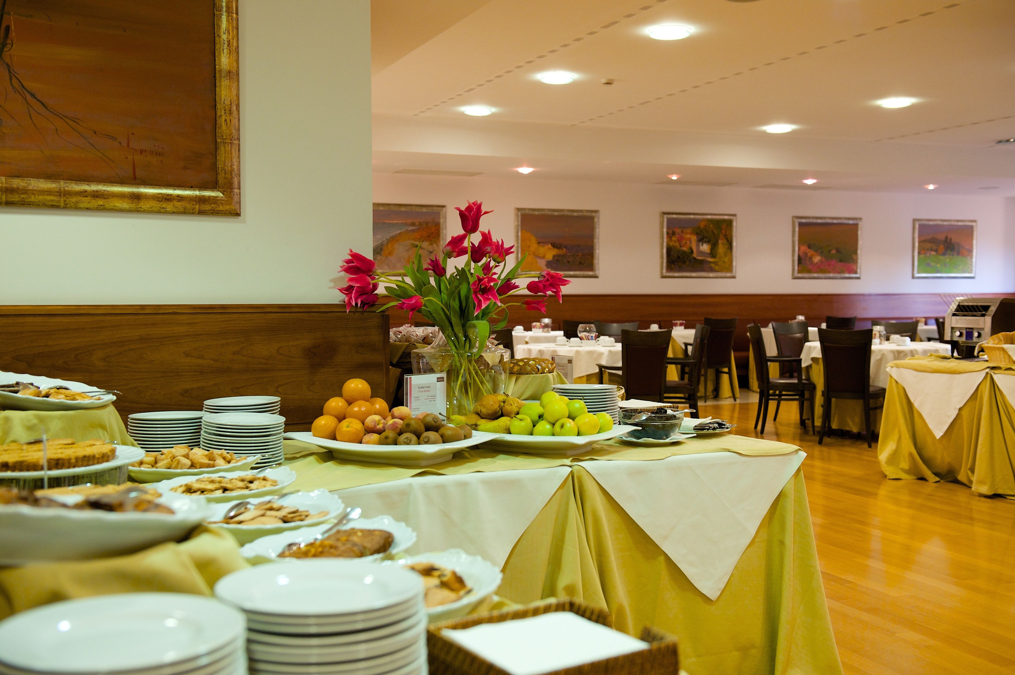 A buffet setup with various food items and a floral centerpiece.