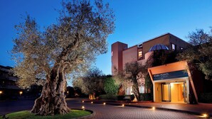 A building with a modern architectural style, featuring a prominent entrance with a sign that reads "FOUR POINTS." - Four Points by Sheraton Siena (Siena)