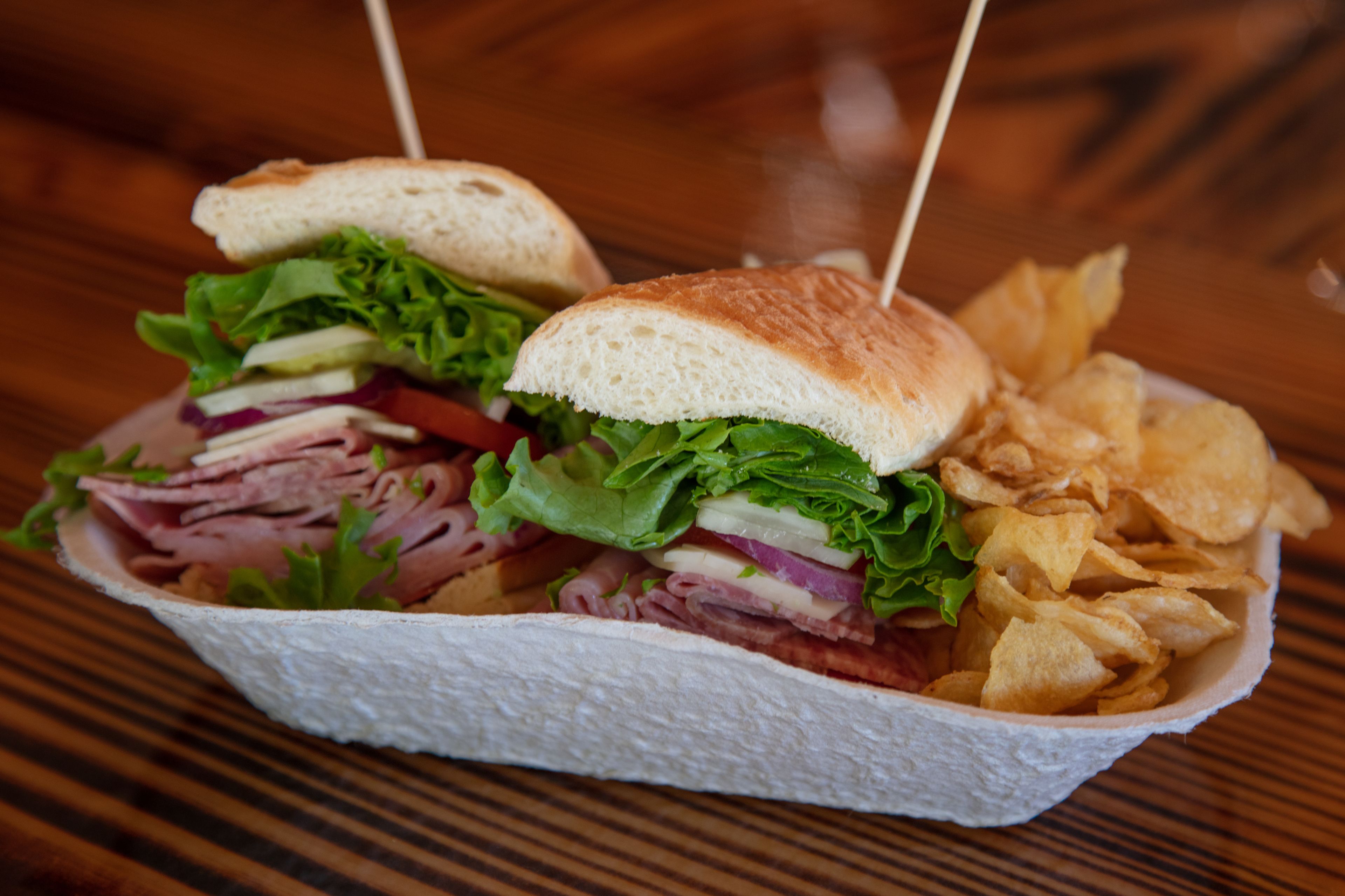 Ein Sandwich mit Zahnstocher, Salat und Pommes.
