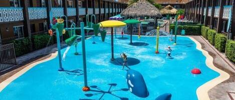 A water park with slides, a pool, and thatched-roof structures.