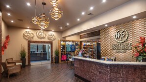 A reception area with a check-in counter, a seating area with chairs, and a display of local crafts. - Westgate Cocoa Beach Resort (Cocoa Beach)