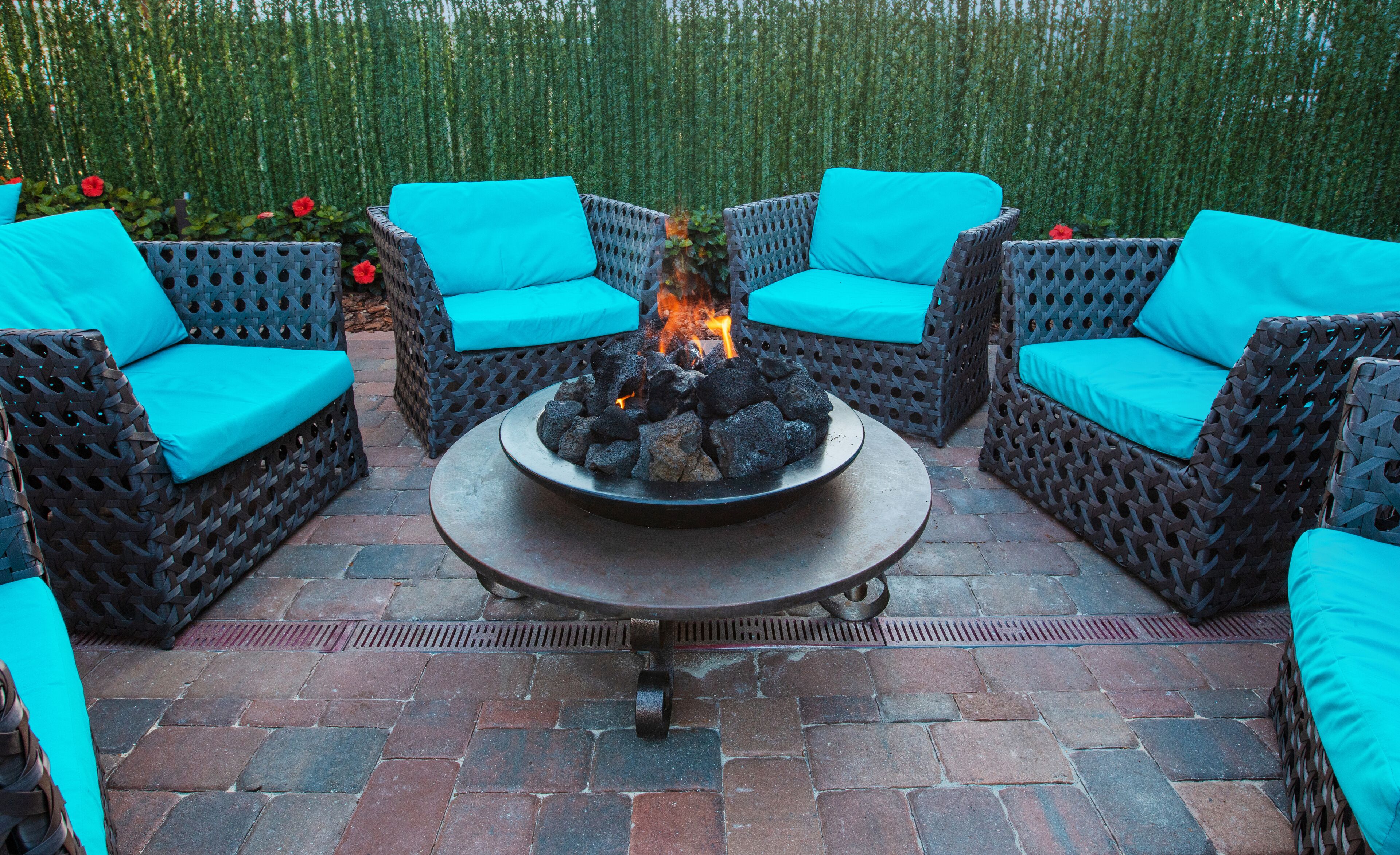 Un patio amueblado con muebles de mimbre y una chimenea en el centro.