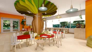 Un moderno cuarto de juegos para niños con un gran árbol como pieza central, mesas redondas y sillas coloridas.
