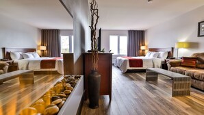 Une chambre d’hôtel avec deux lits, un plancher en bois, un vase décoratif et une vue sur l’extérieur.