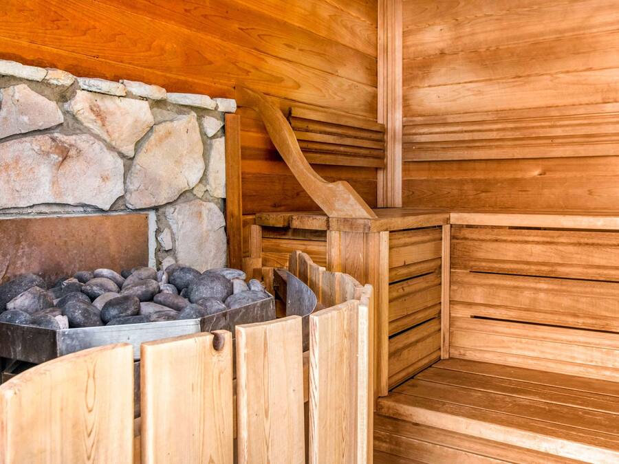 Una sauna con bancos de madera y una pared de piedra.