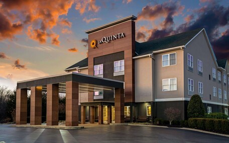 A hotel with a modern design, featuring a prominent entrance with a covered area and multiple windows.