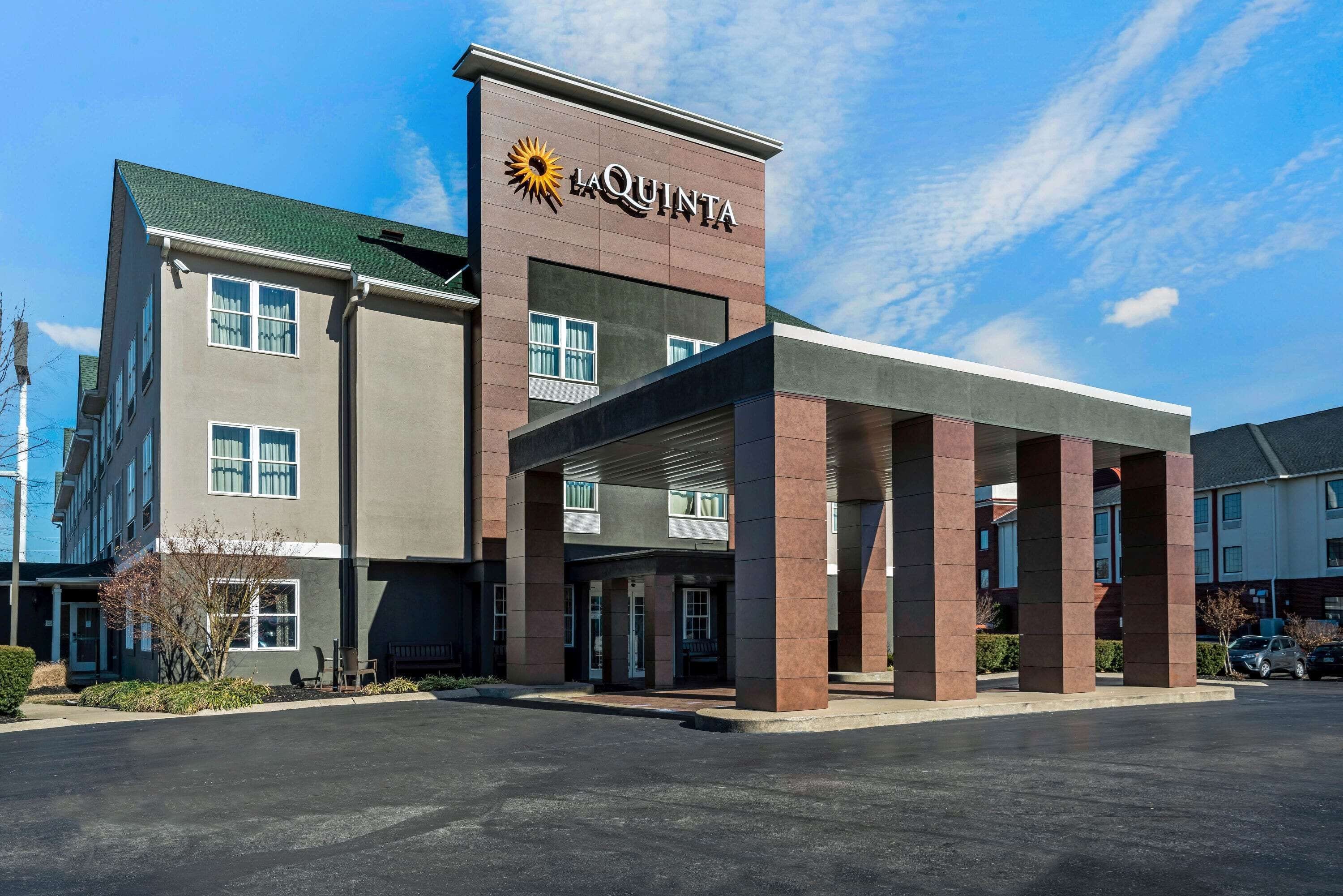 A hotel with a prominent 'La Quinta' sign, a covered entrance, and a parking lot.