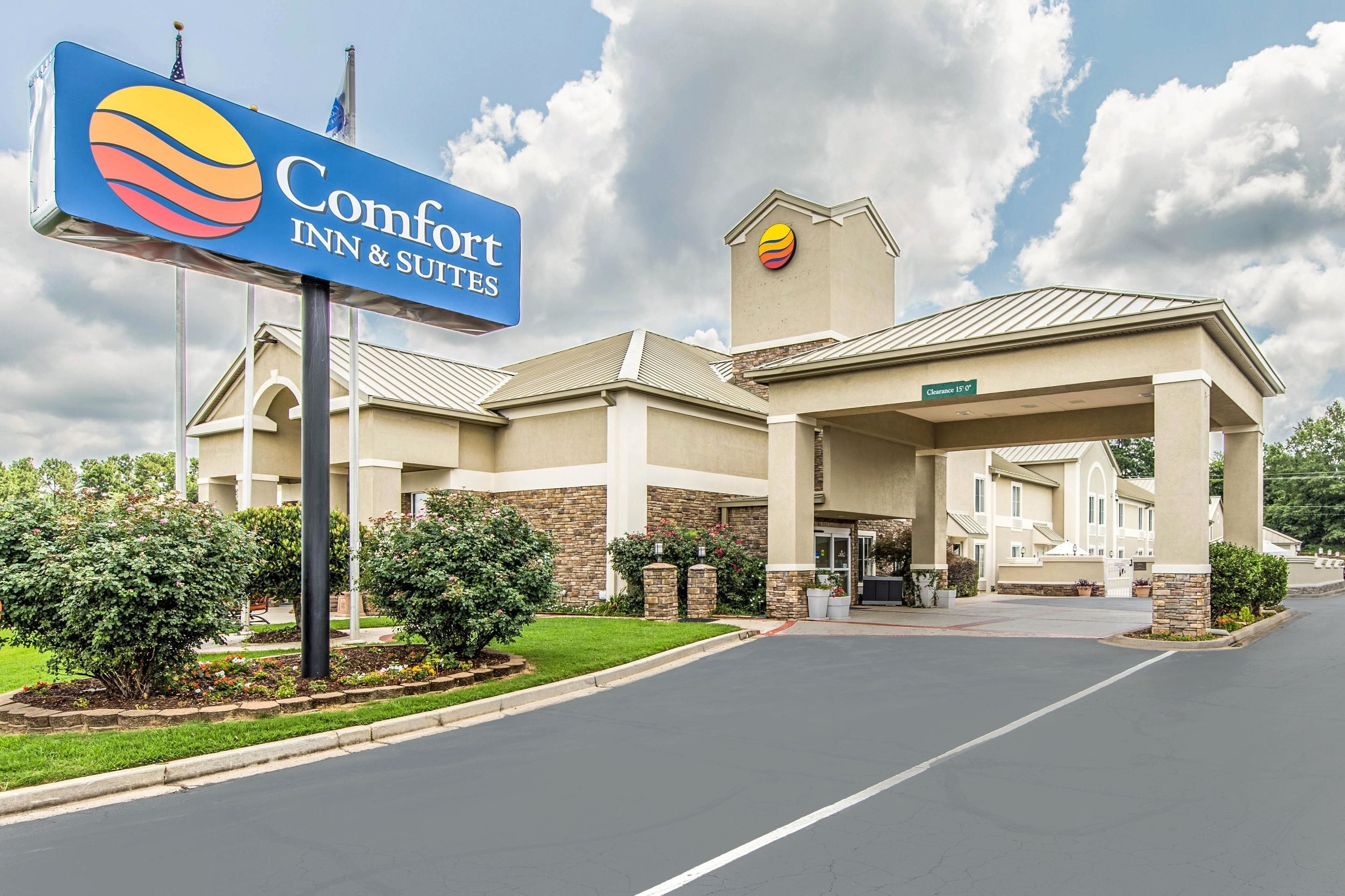 Un hotel Comfort Inn & Suites con cielo despejado y un césped bien cuidado al frente.