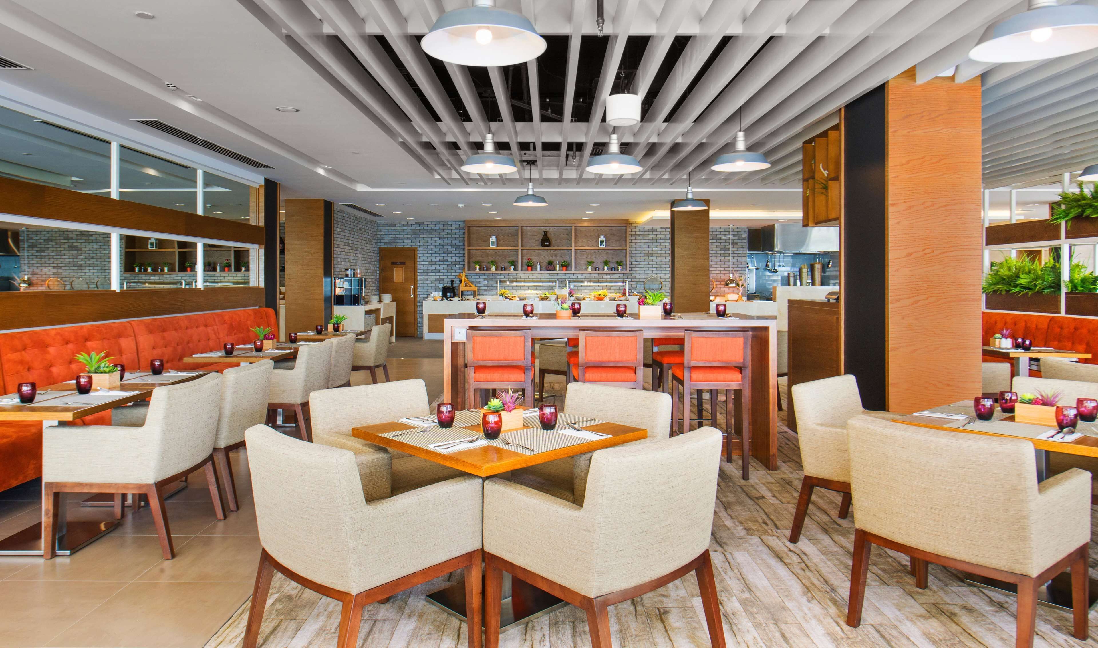 A modern restaurant with a brick wall, wooden accents, and a central bar area.