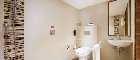 Un baño moderno con ducha, inodoro y lavamanos.