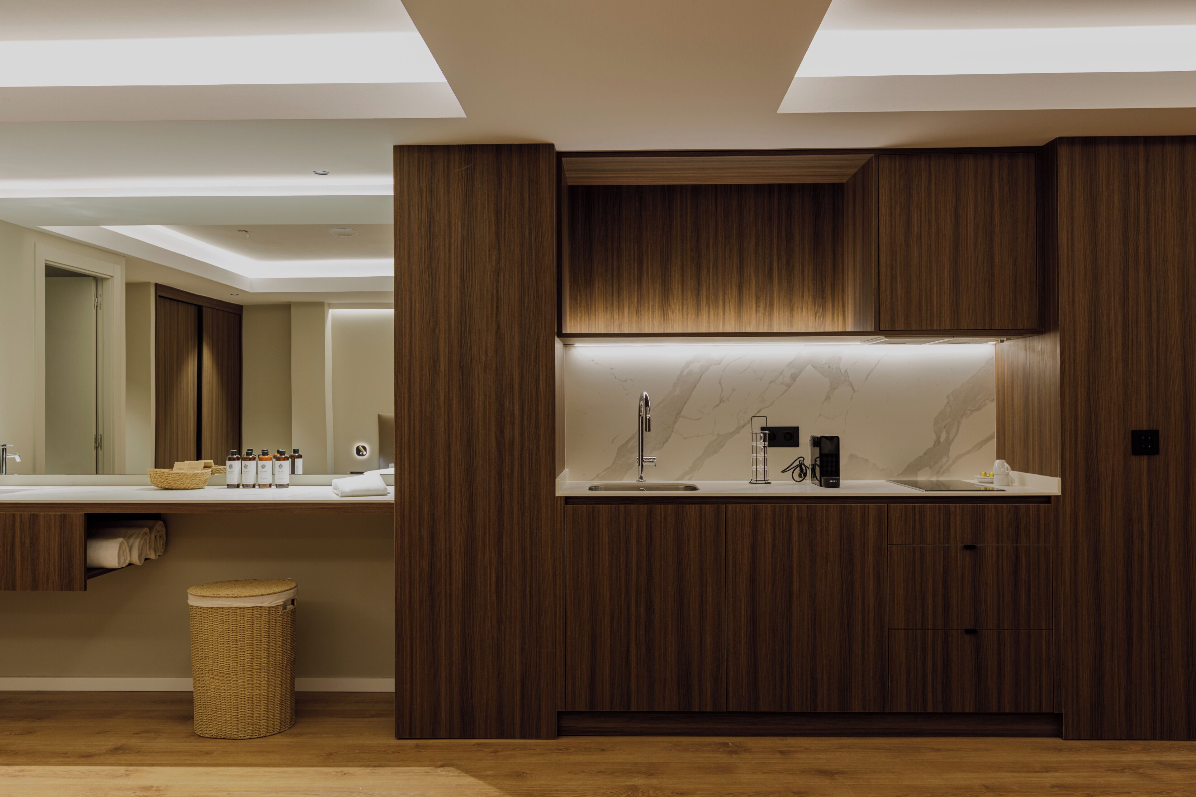A modern kitchen with wooden cabinetry, a marble countertop, and a built-in sink.