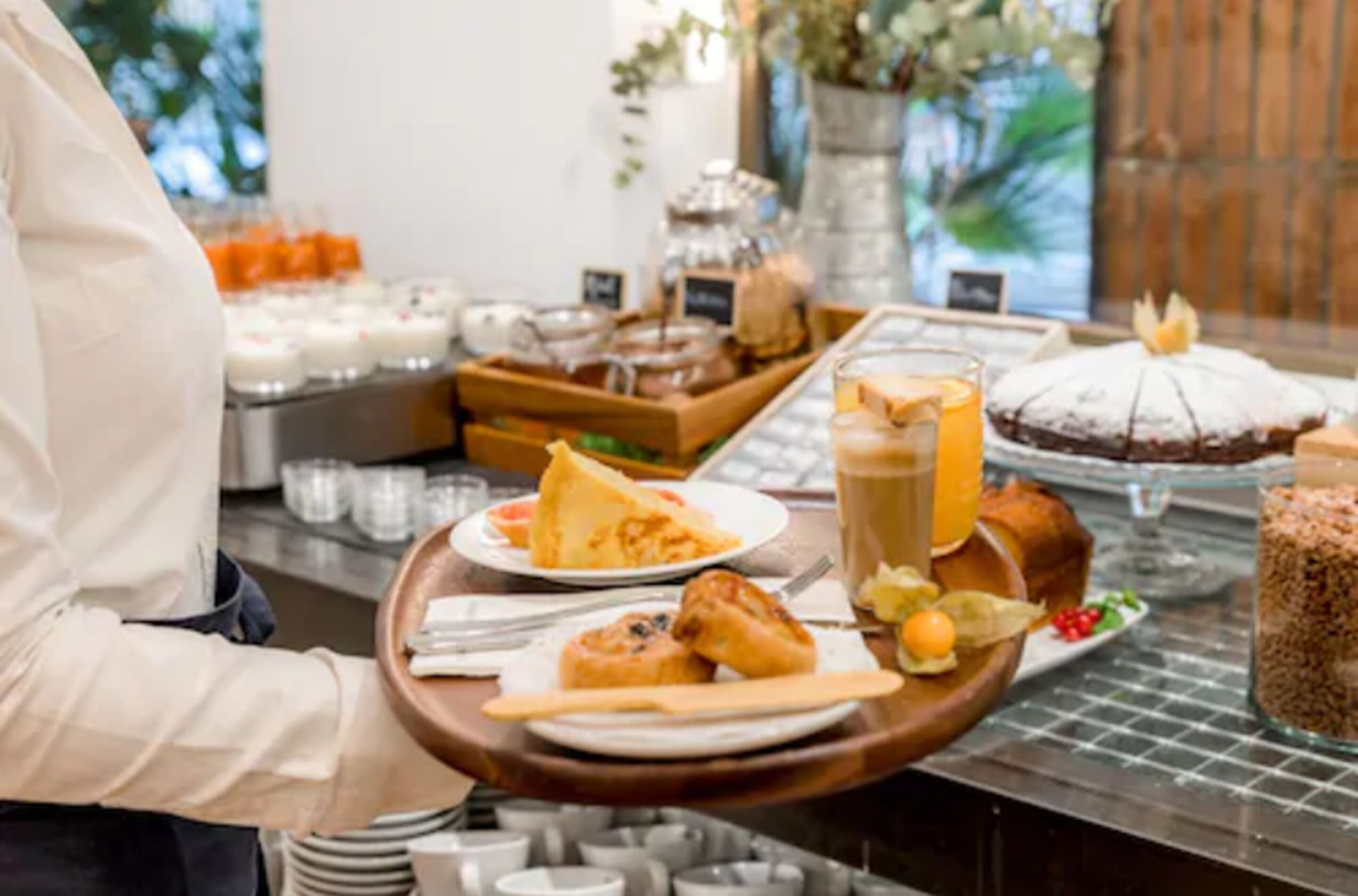 Un buffet proposant une variété de plats, notamment des pâtisseries, un gâteau et des boissons.
