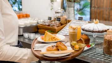 Un buffet proposant une variété de plats, notamment des pâtisseries, un gâteau et des boissons.
