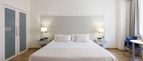 Minibar, caja fuerte, cortinas opacas y tabla de planchar con plancha