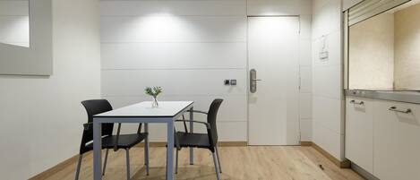 Una cocina moderna con armarios blancos, encimera de madera y horno empotrado.