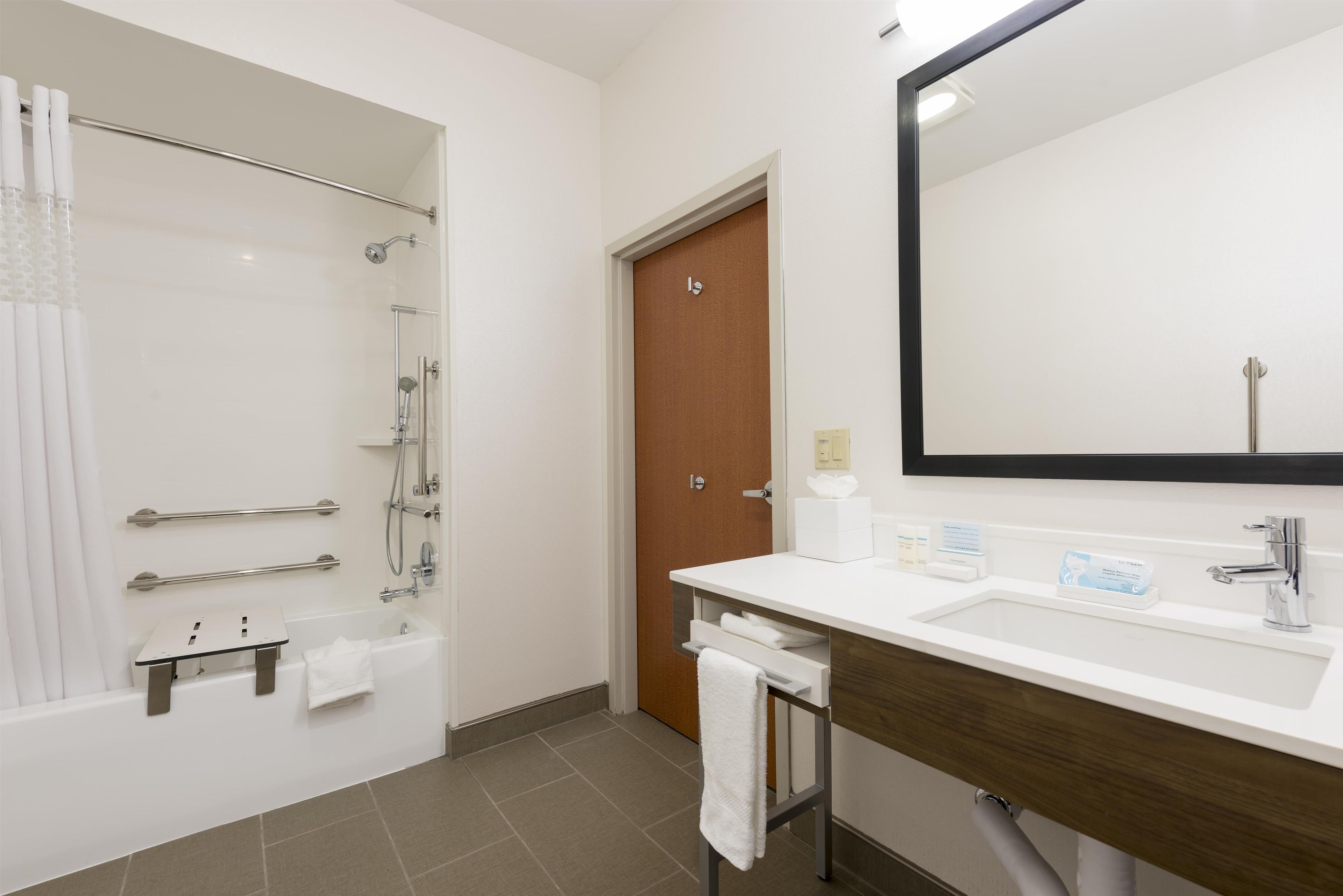 A modern bathroom with a shower, toilet, and sink.