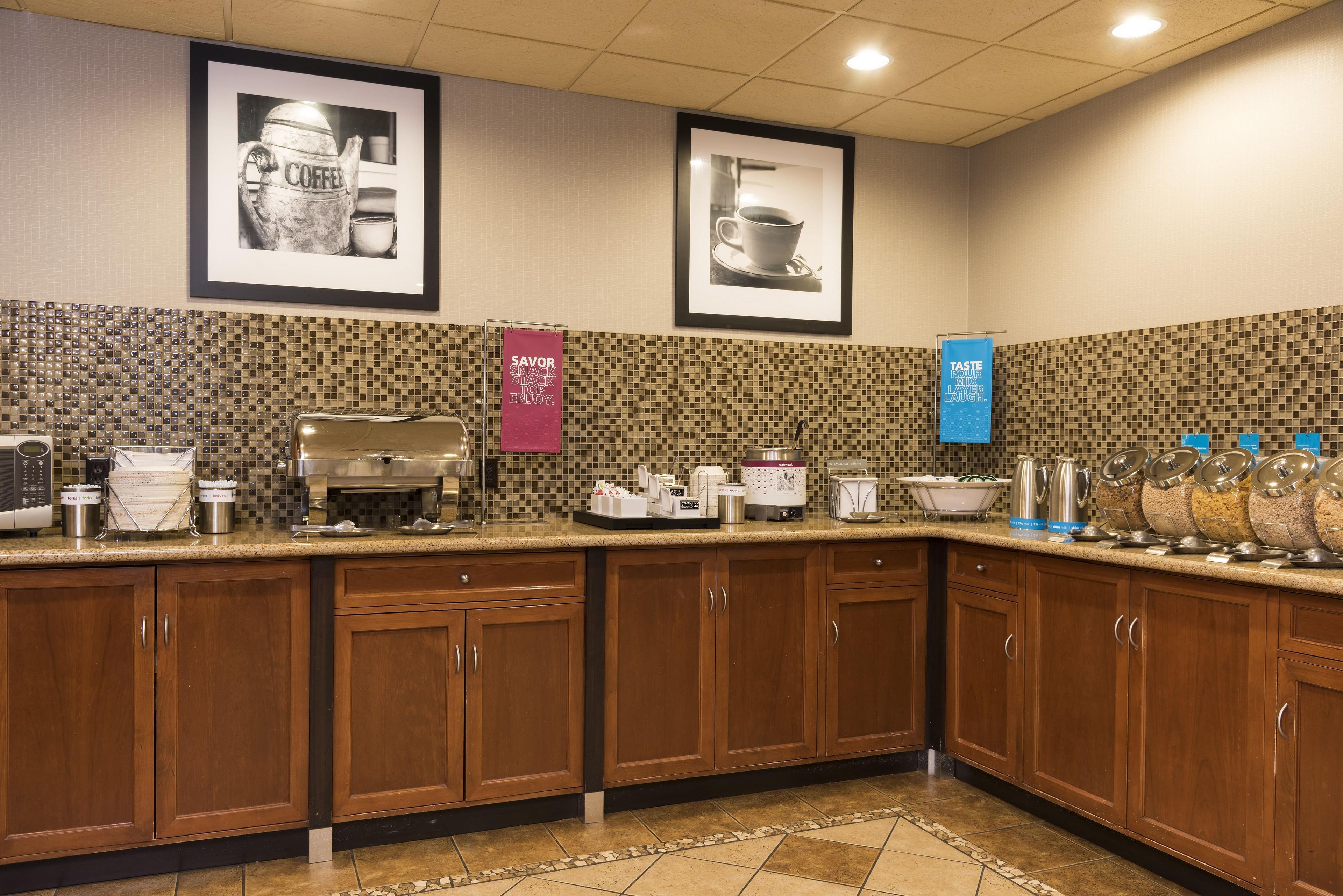 A hotel kitchen with a coffee station, a food display, and a beverage dispenser.