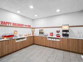 A breakfast area with a sign reading 'HAPPY BREAKFAST STARTS HERE.'