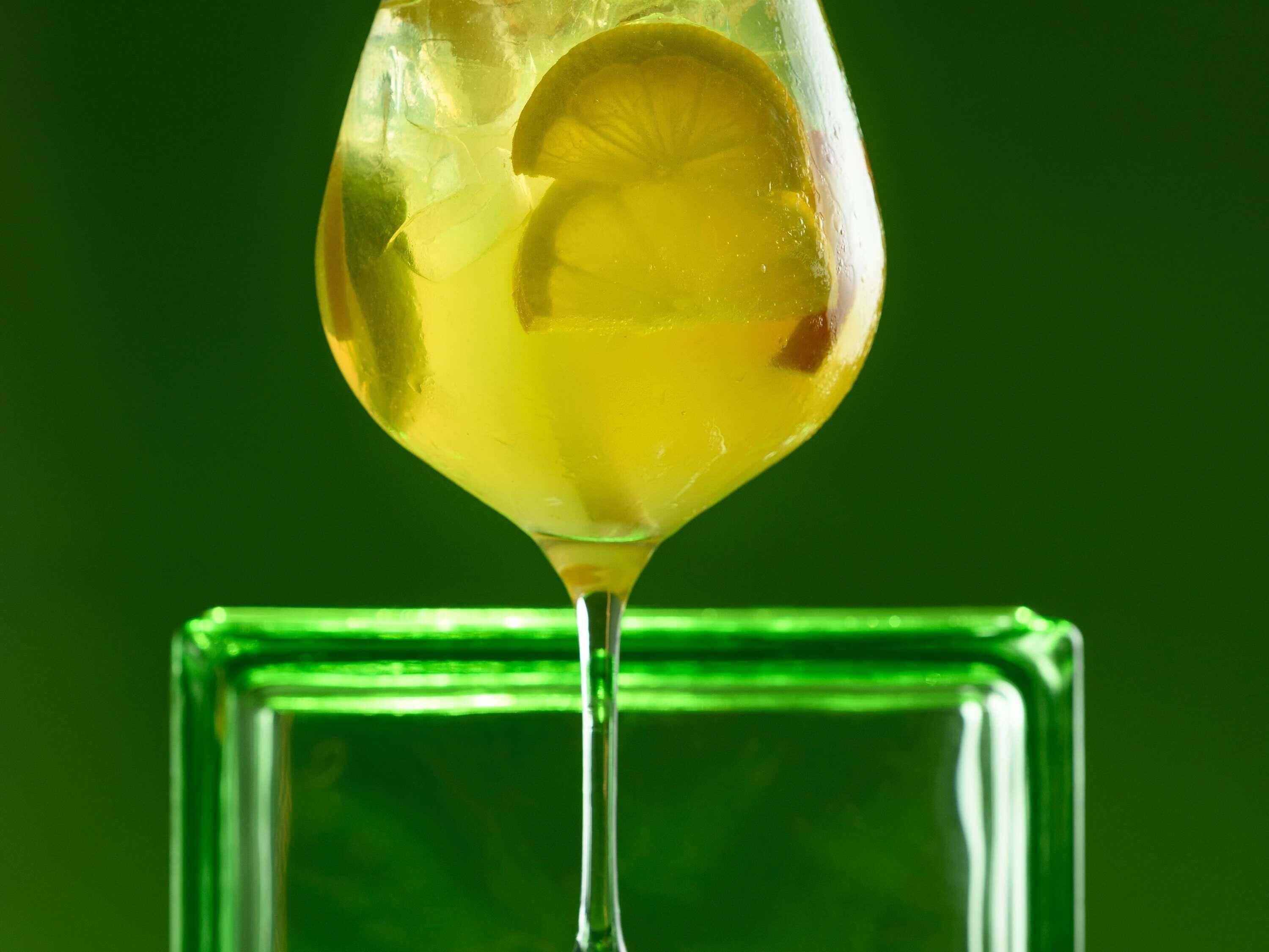 A clear glass with a lemon slice and ice cubes.