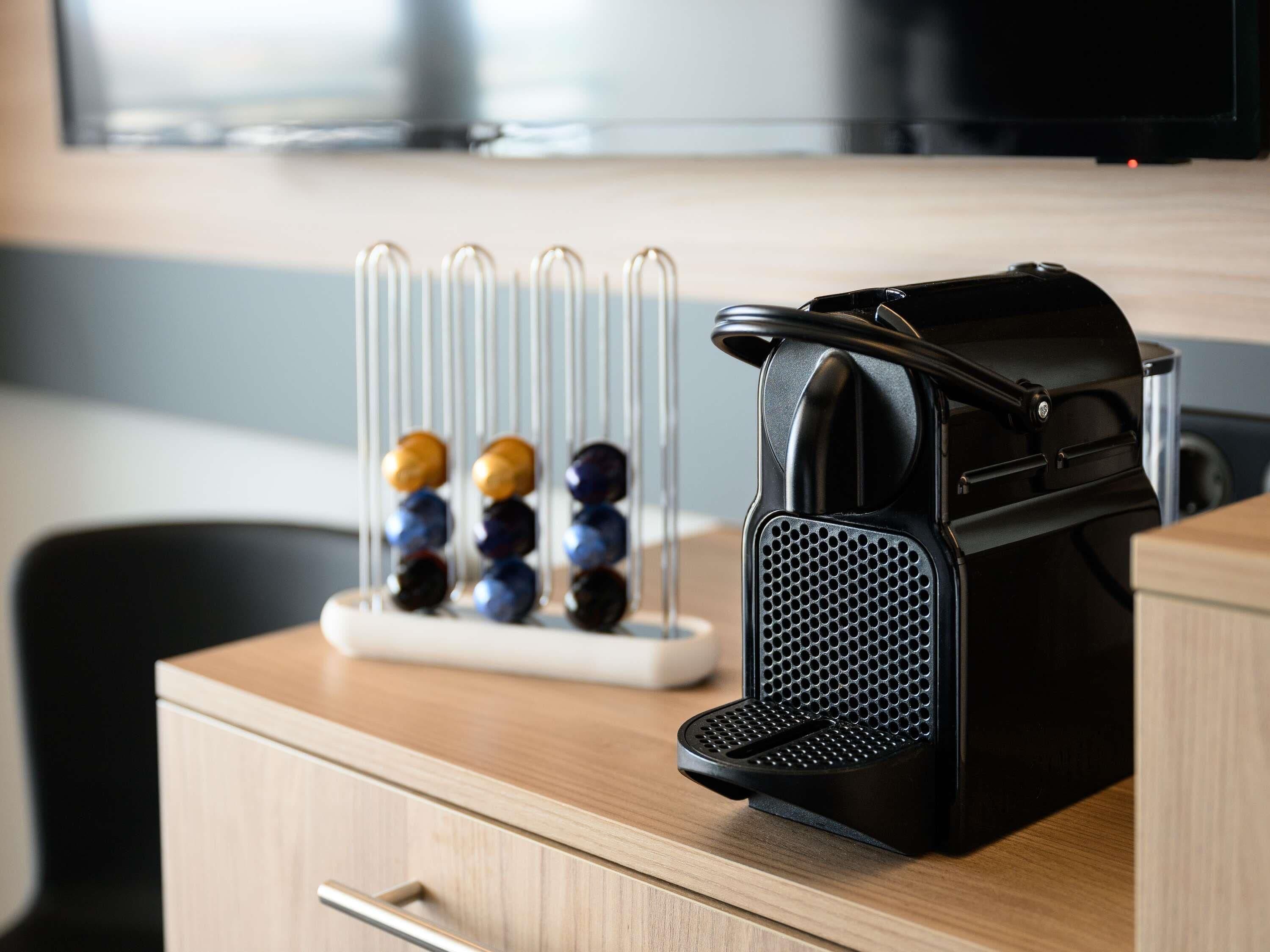 Un coin cuisine équipé d’une machine à café et d’un assortiment de perles colorées présentées sur un présentoir.
