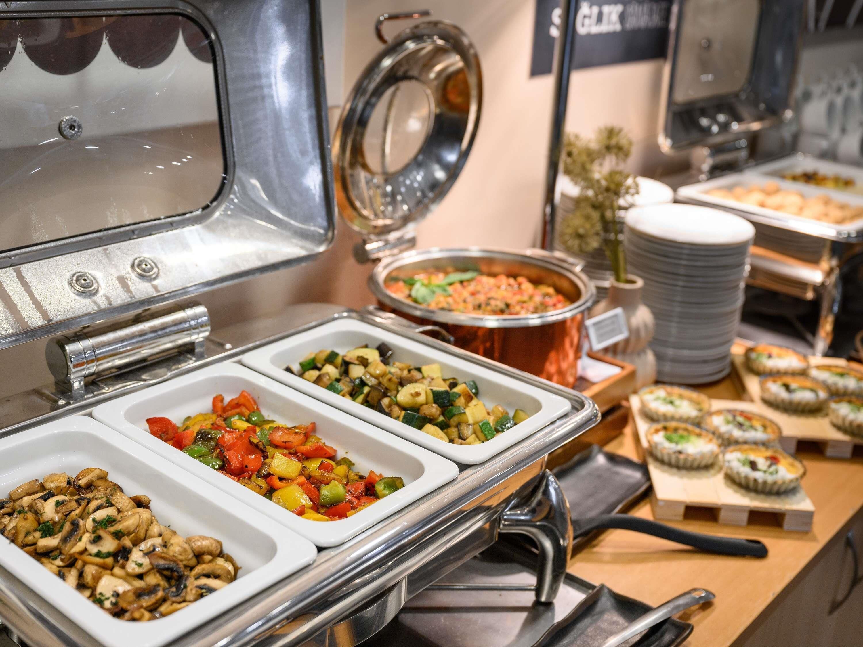 Un buffet proposant une variété de plats, notamment des légumes et des champignons.