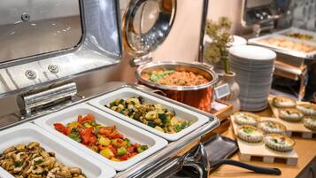 Un buffet proposant une variété de plats, notamment des légumes et des champignons.