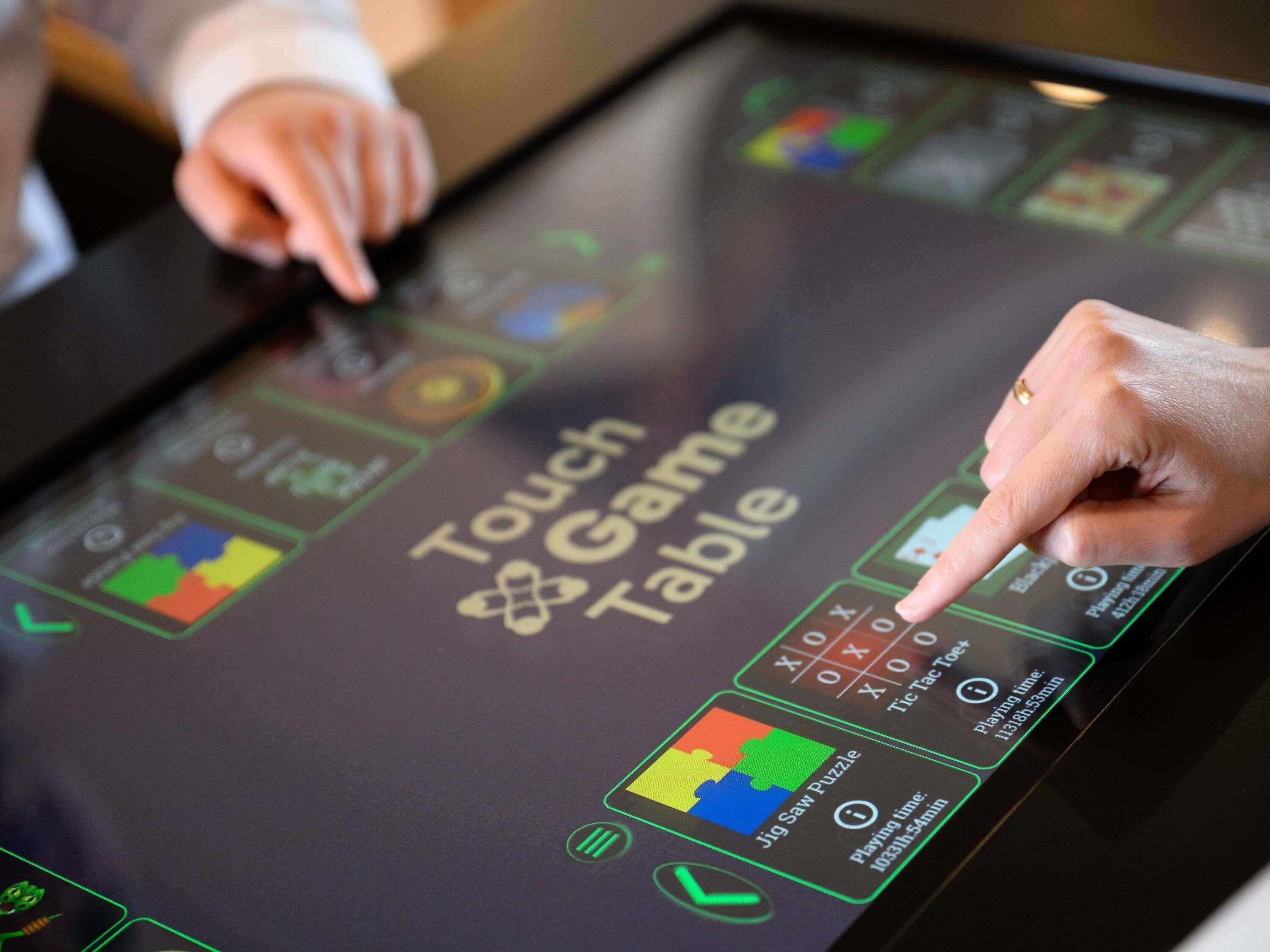 A touchscreen table with various game options, including a jigsaw puzzle.