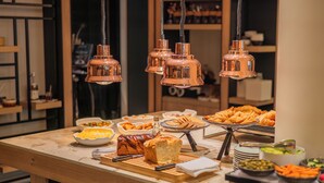 Ein Buffet mit verschiedenen Speisen, darunter Brot, Gebäck und Gemüse.