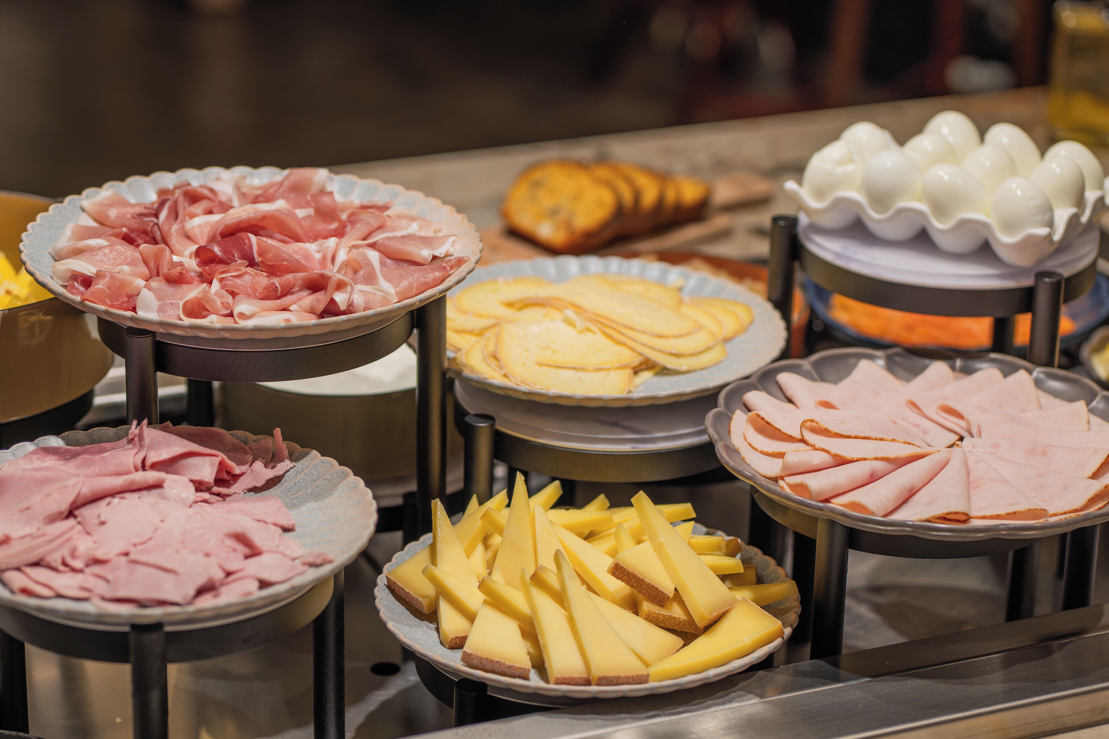 A buffet with various food items including sliced meats and cheeses.