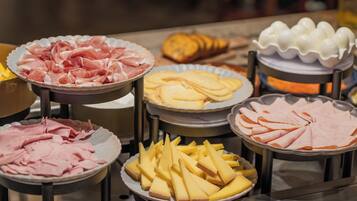 A buffet with various food items including sliced meats and cheeses.
