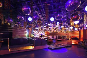 A room with multiple disco balls, seating areas, and a stage. - Holiday Inn Monclova by IHG (Monclova)