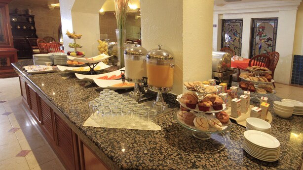Una mesa de buffet con diversos alimentos y bebidas.