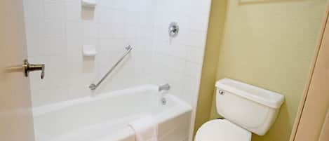 A bathroom with a bathtub, toilet, and a towel rack.