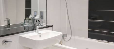 Un baño moderno con un lavabo blanco, un espejo y una bañera.