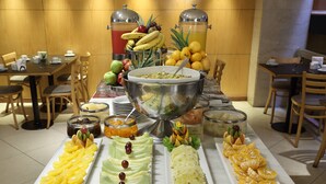A buffet with various fruits and beverages. - Dolmen Hotel (Buenos Aires)