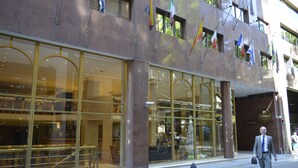 A hotel with large glass windows, a modern facade, and multiple flags. - Dolmen Hotel (Buenos Aires)