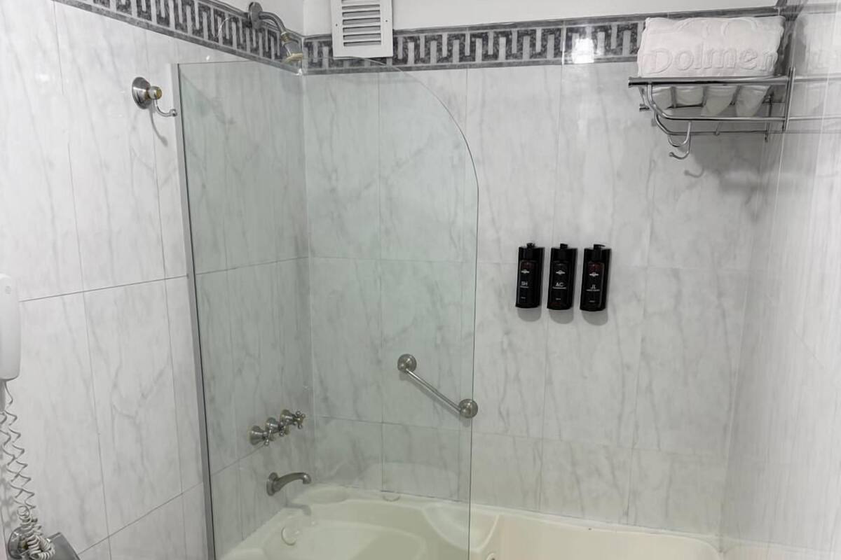 A bathroom with a glass-enclosed shower, a bathtub, a bidet, and a toilet.