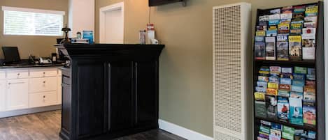 A kitchen with dark wooden cabinets, a white countertop, a built-in stove, and a wall-mounted TV.