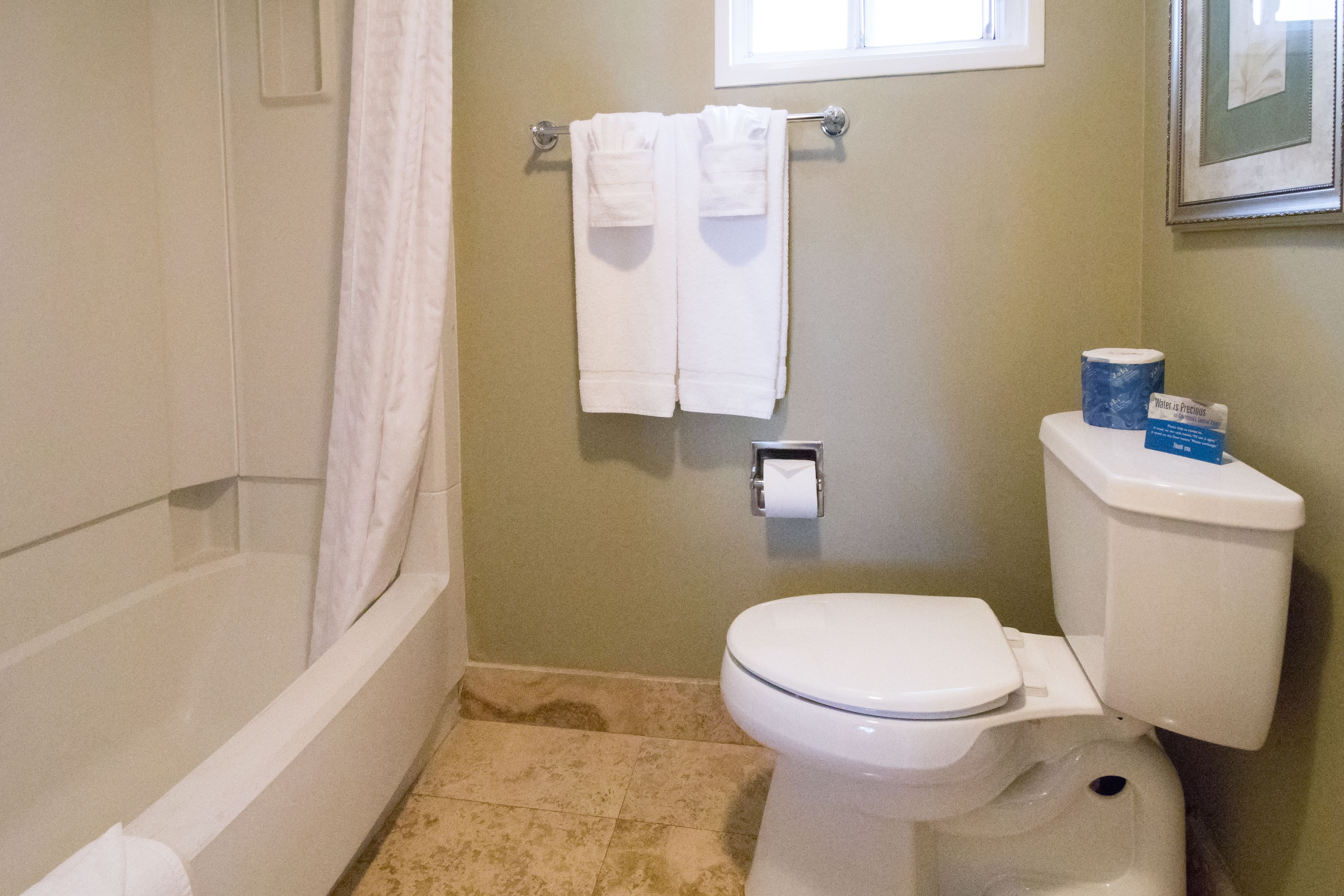 Une salle de bain équipée d’une baignoire, de toilettes et d’un porte-serviettes avec deux serviettes.