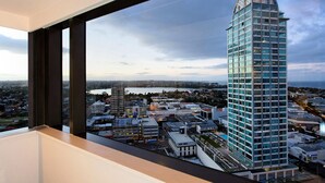 A high-rise building with a unique architectural design, viewed from a window overlooking a cityscape. - The Spencer Suites By Castle (Auckland)