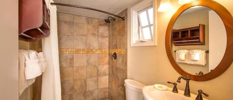 Un baño con ducha, inodoro y lavamanos.