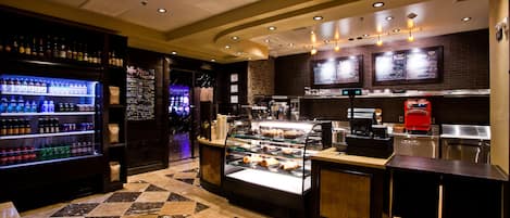 A restaurant with a deli counter, a beverage cooler, and a coffee machine.