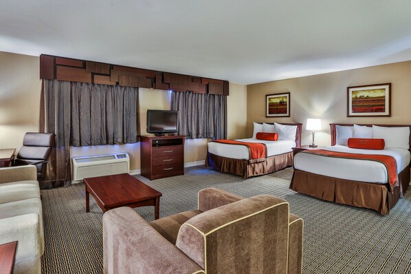 A hotel room with a bed, two bedside tables, a TV, a desk, and a chair.
