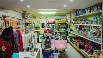 A store with shelves of bags and accessories, a Coca-Cola refrigerator, and a 'MOVIE NIGHT' sign.
