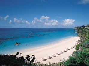 Rannalla, valkoista hiekkaa, aurinkotuoleja, aurinkovarjoja