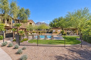 Zona residencial con piscina, patio cercado y vistas a la montaña.