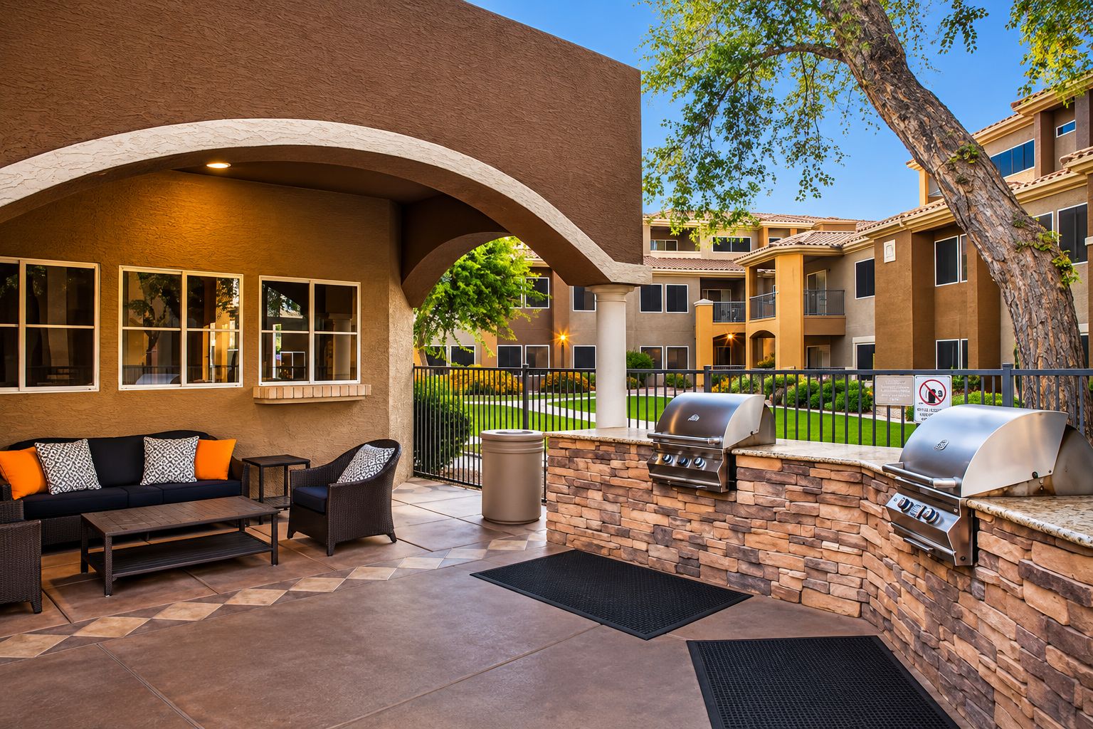 An outdoor patio with a barbecue grill, seating area, and a stone wall.