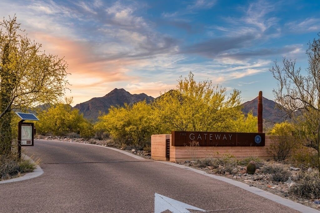 A road leading to a sign labeled 'The Gateway' with a mountainous backdrop.
