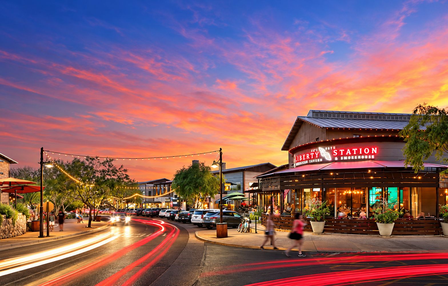 Un restaurant avec une terrasse et une vue sur la rue au crépuscule.