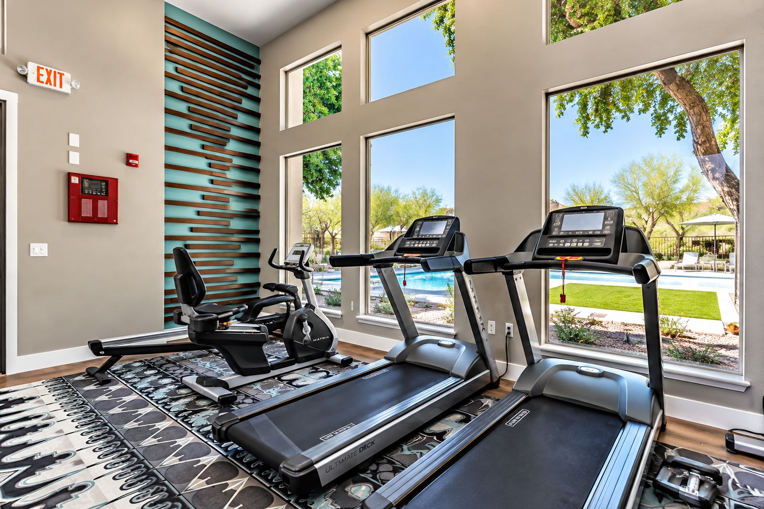 A fitness room with treadmills, a stationary bike, and a rowing machine.